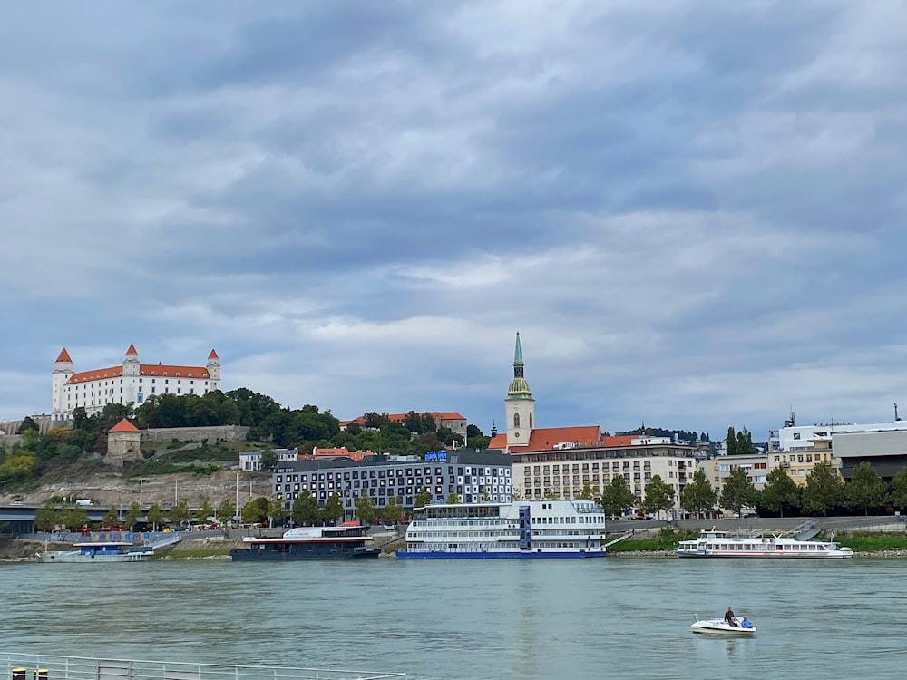 a body of water with boats in it and a castle in the background