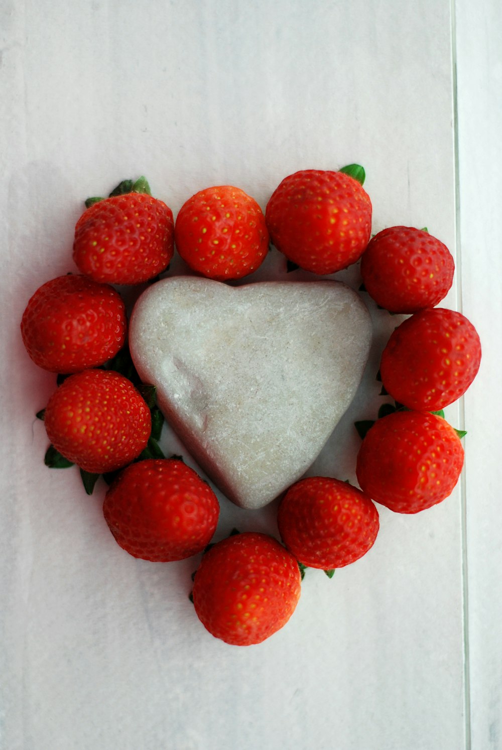 a heart shaped cake surrounded by strawberries