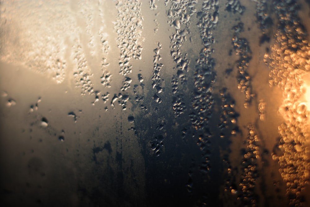 rain drops on a window with a street light in the background