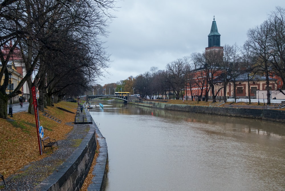 a river running through a city with a clock tower in the background