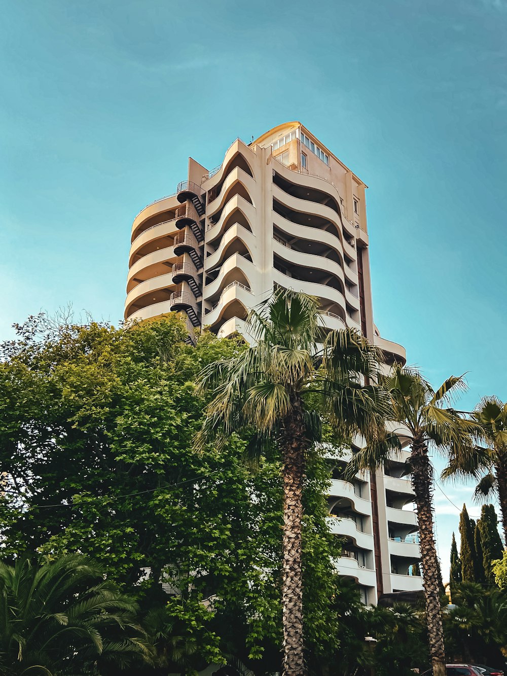 a tall building with palm trees in front of it