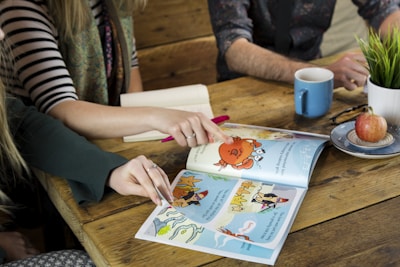 A family gathered around a table discussing finances with illustrated storybooks open.