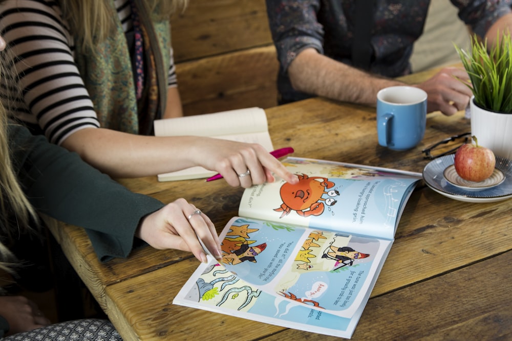 a person sitting at a table with a book