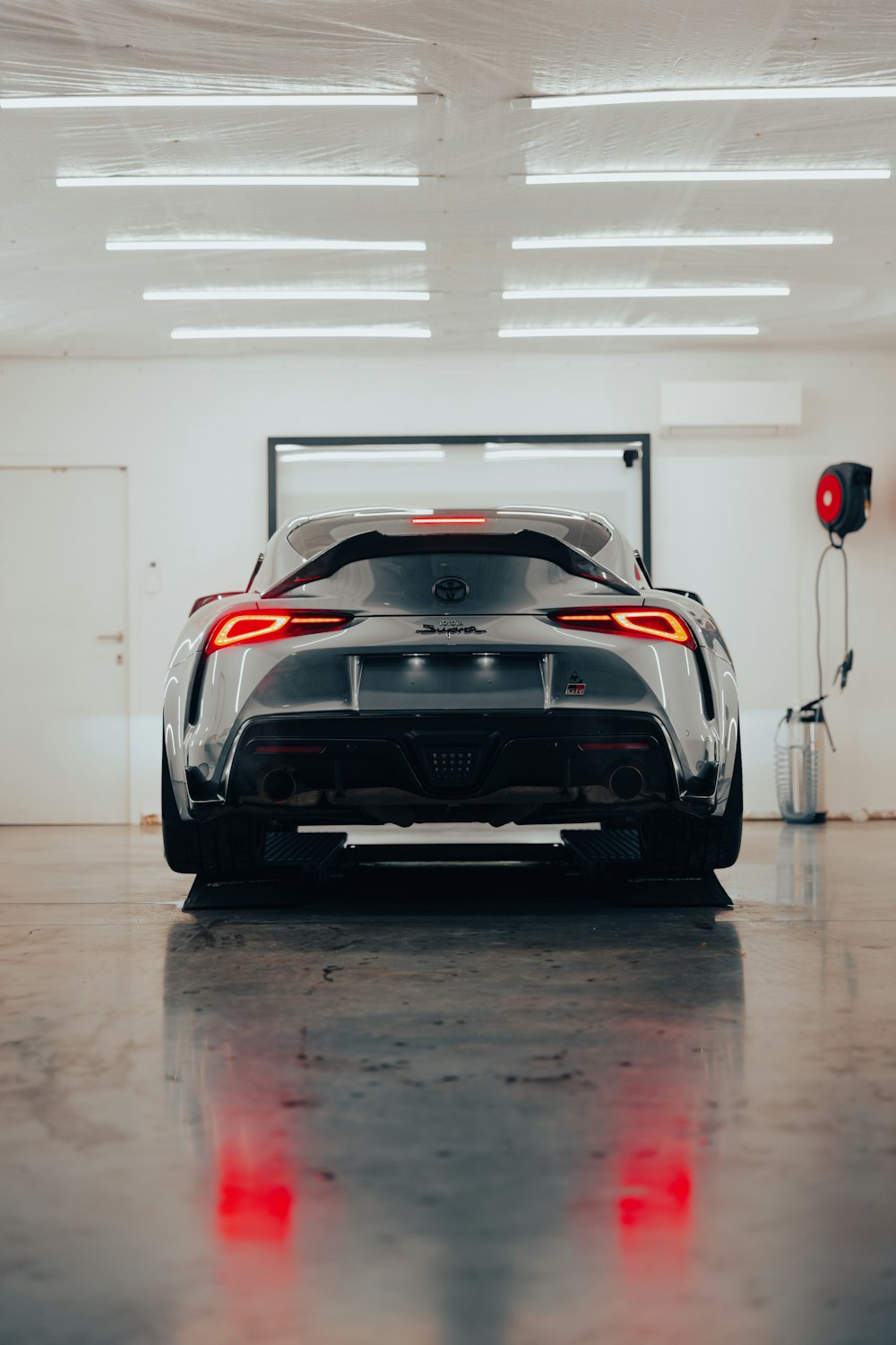 the rear end of a sports car parked in a garage