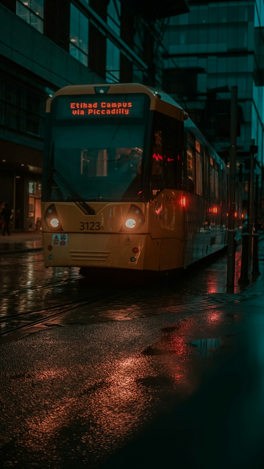 a city bus driving down a street at night