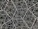 An intricate geometric pattern composed of interlocking hexagonal shapes, creating a sense of infinite depth. The design appears metallic with a dark background, giving the illusion of a three-dimensional structure.