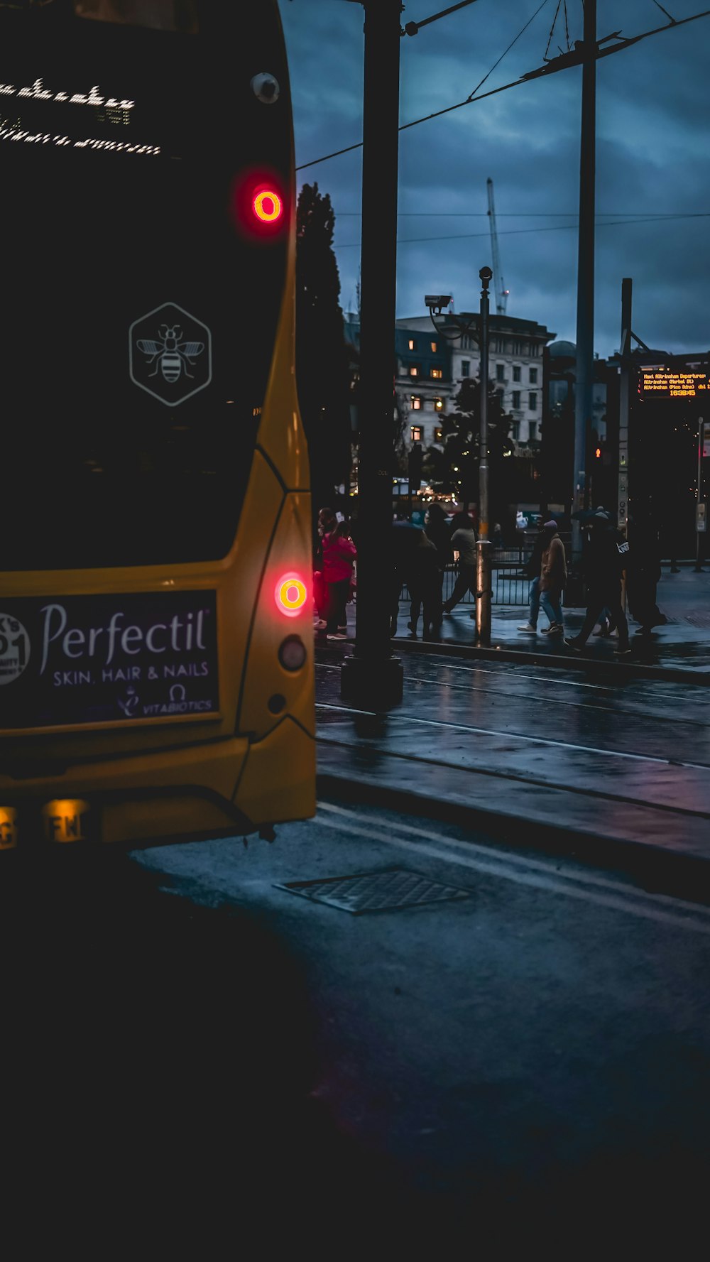 a bus is stopped at a bus stop on a rainy night