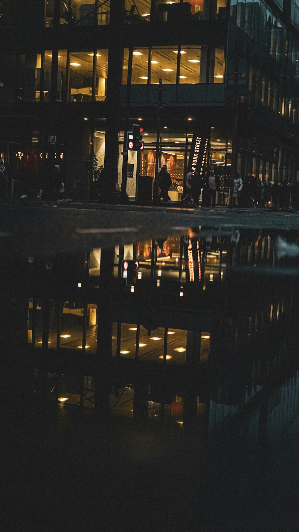 a building with a reflection in the water at night