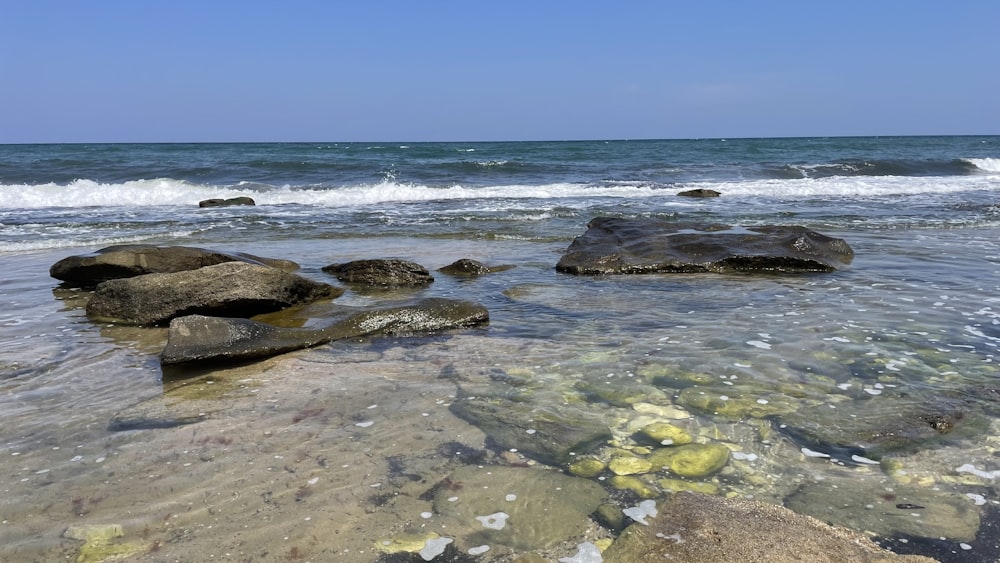 a rocky beach with waves coming in and out of the water