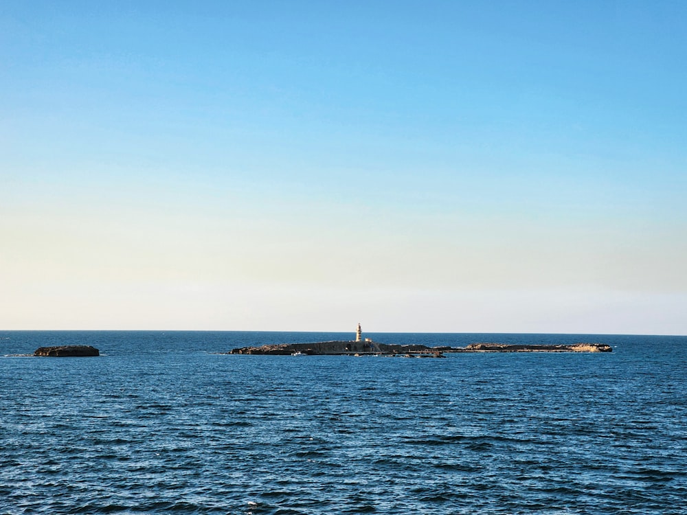 a large body of water with a light house in the distance