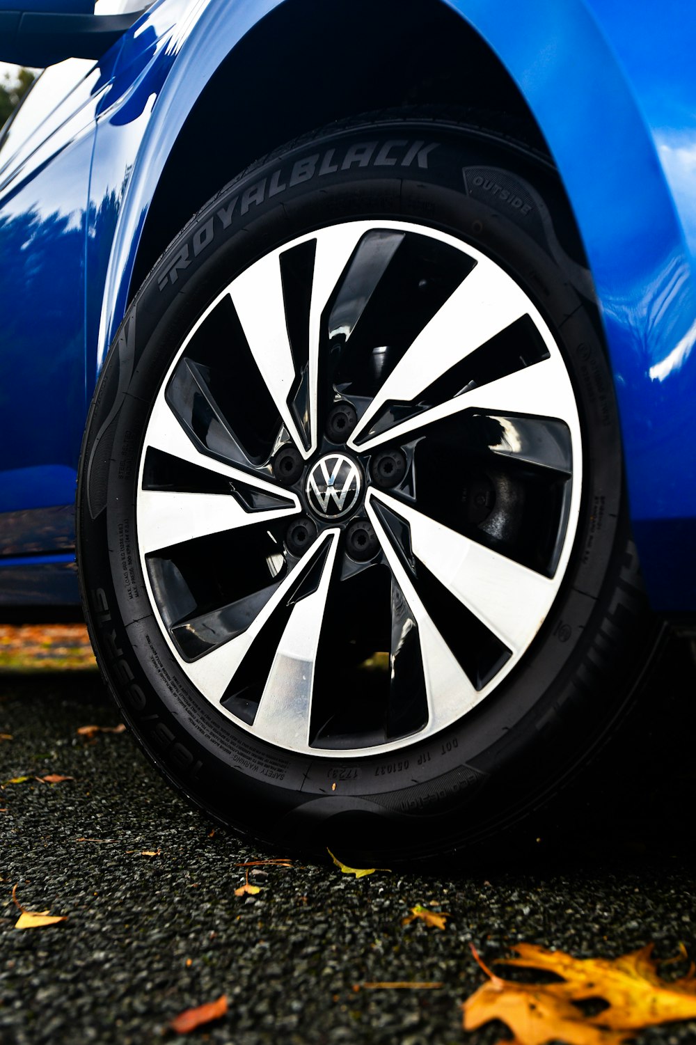 a close up of a blue car with black and white spokes