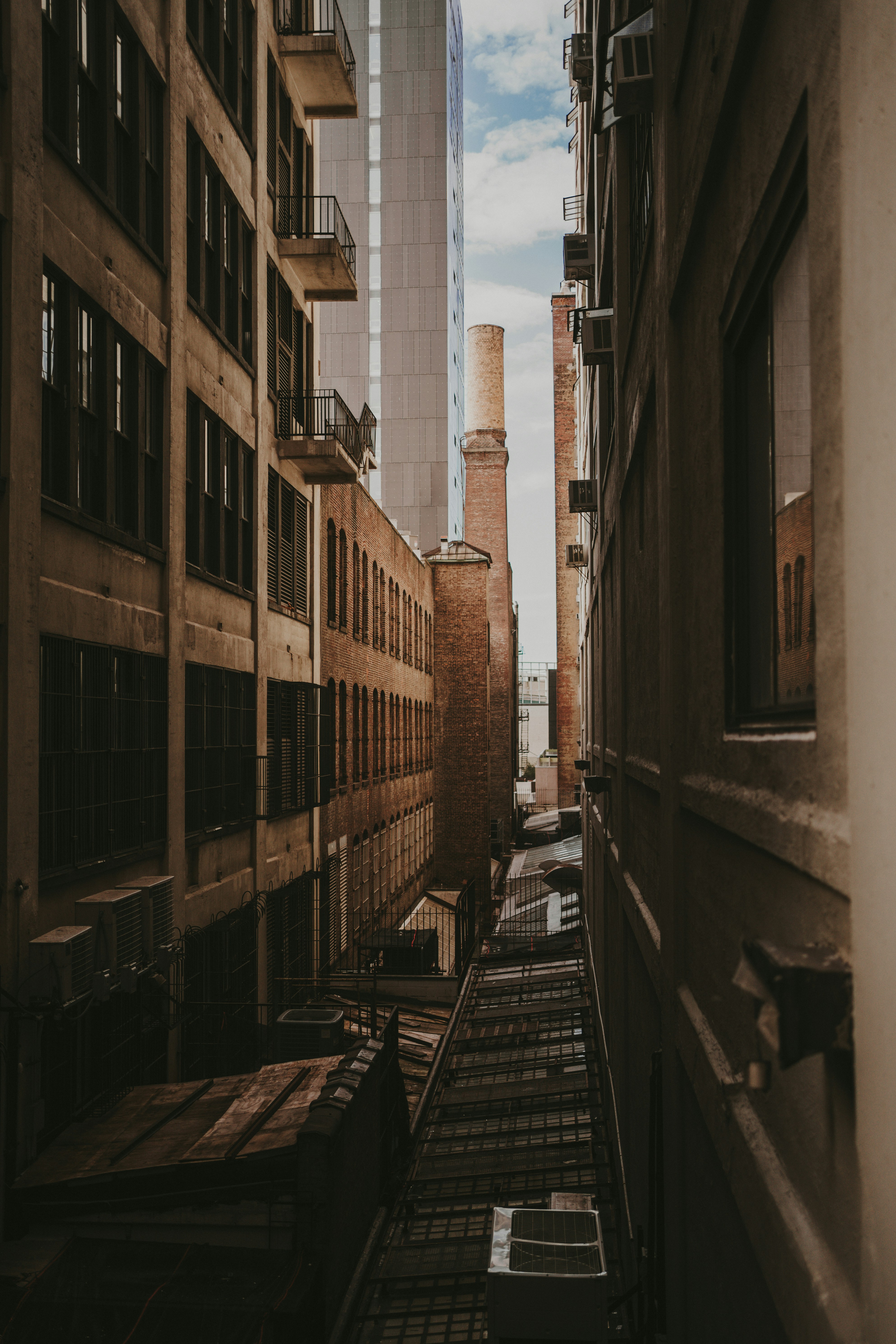 A narrow city street with tall buildings in the background photo – Free ...