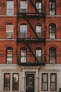 Cozy brick apartment building with fire escapes in NYC neighborhood