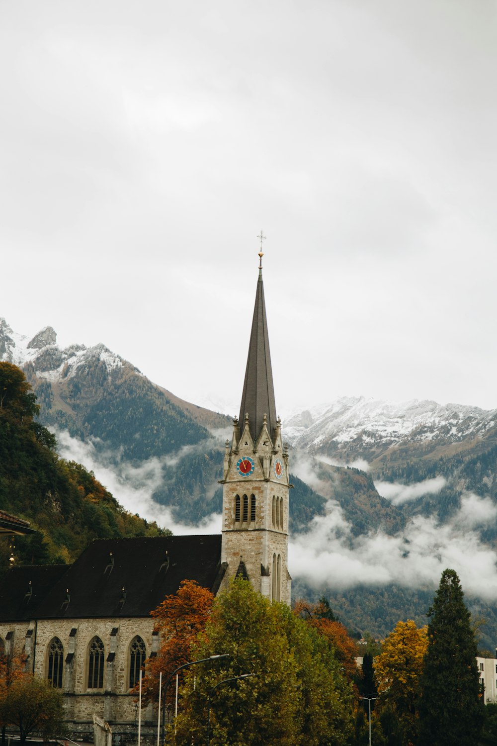 a church with a steeple surrounded by mountains