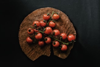 A vibrant splash of ripe tomatoes bursting against a rustic wooden background, symbolizing fresh and lively news.