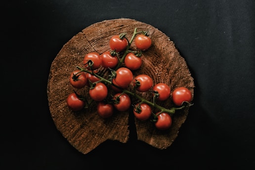 A vibrant splash of ripe tomatoes bursting against a rustic wooden background, symbolizing fresh and lively news.