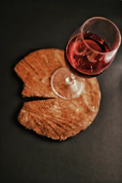 Elegant glass of deep red Cretan wine resting on a rustic wooden table.