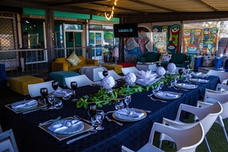 An intimate dining setting with cream-colored tablecloths and intricate black patterns inspired by Clase Azul pottery.