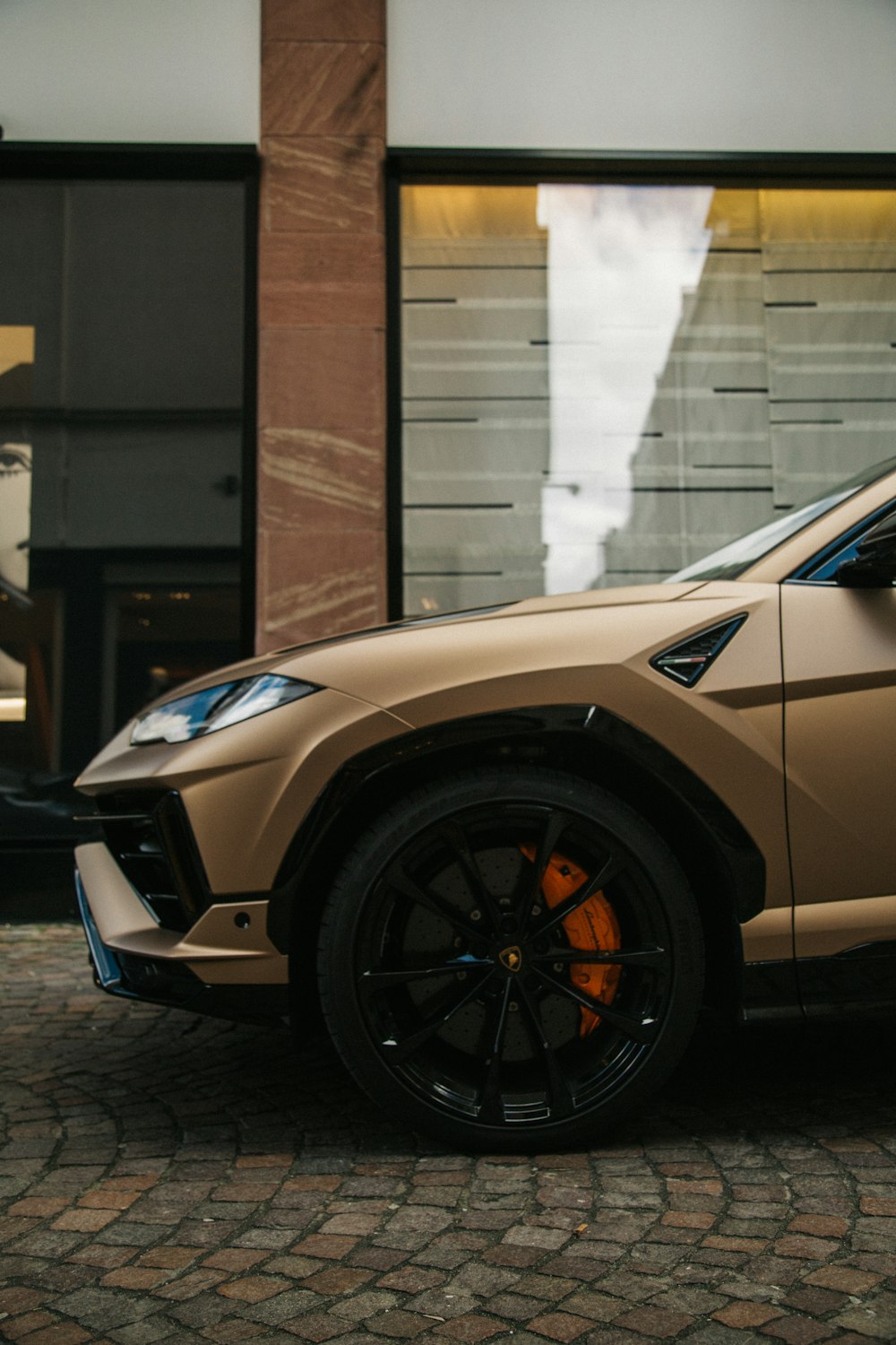 a tan sports utility vehicle parked in front of a building