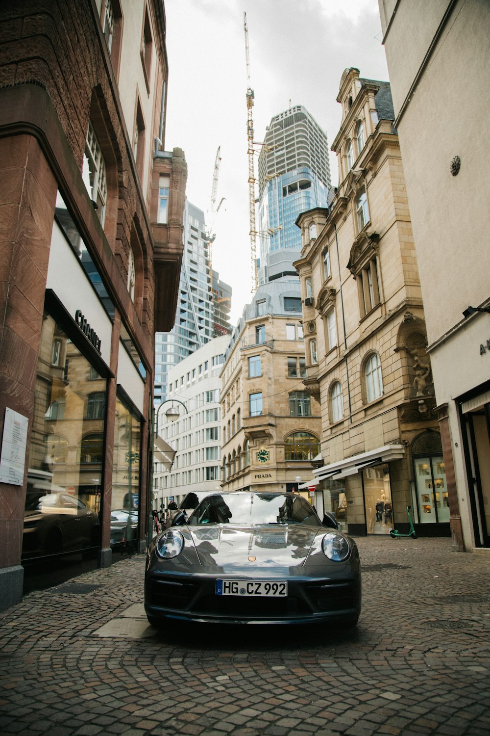 a car parked on the side of a street next to tall buildings