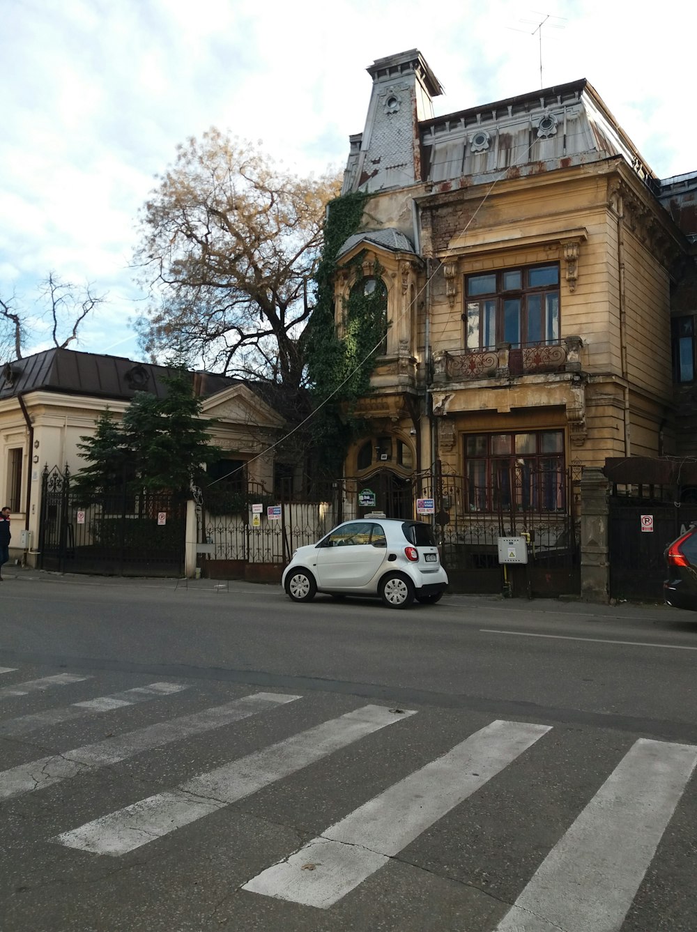 a white car driving down a street next to a tall building