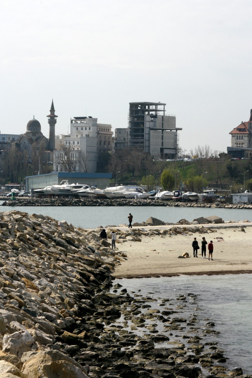 a group of people standing on top of a sandy beach