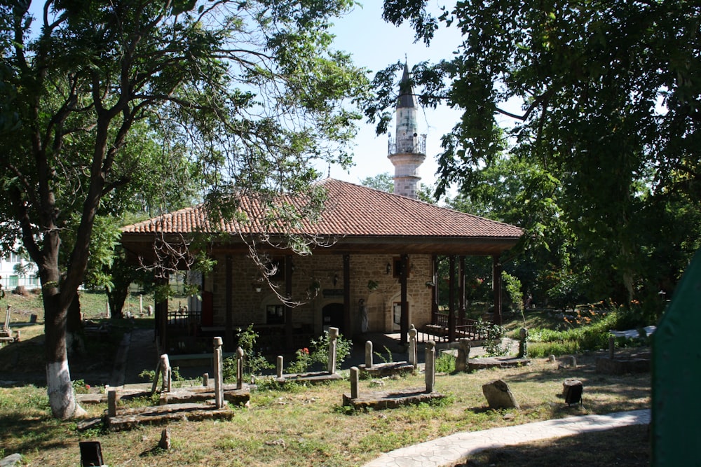 a small building with a tower in the background