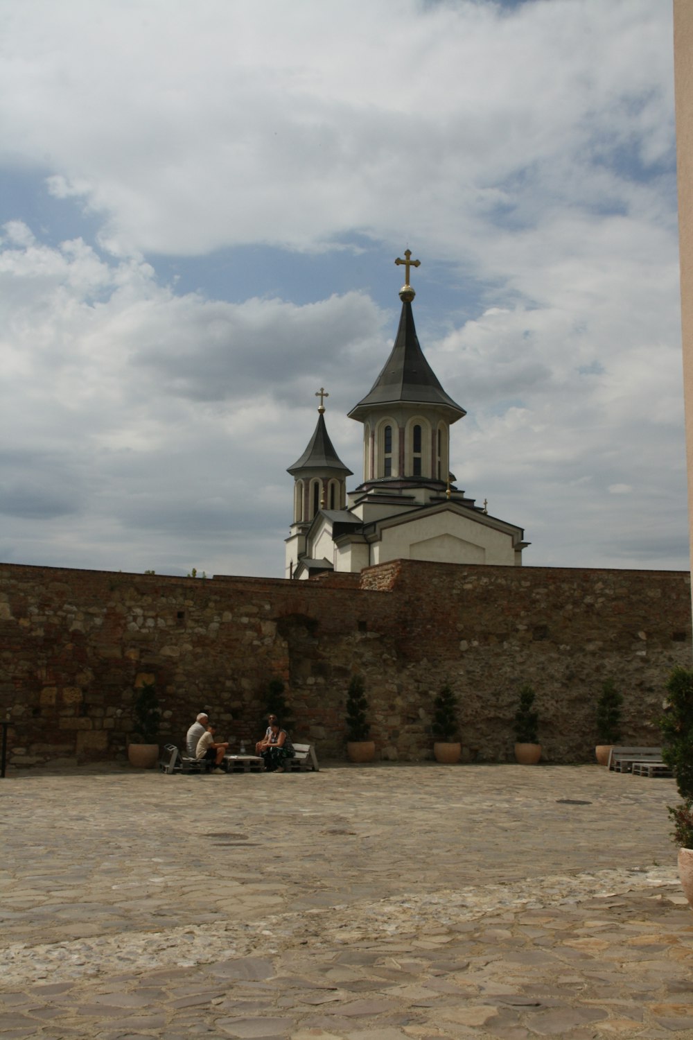 people sitting on a bench in front of a church