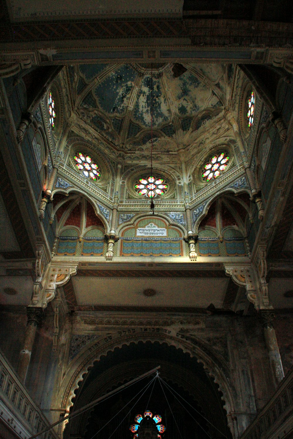 the ceiling of a large building with stained glass windows