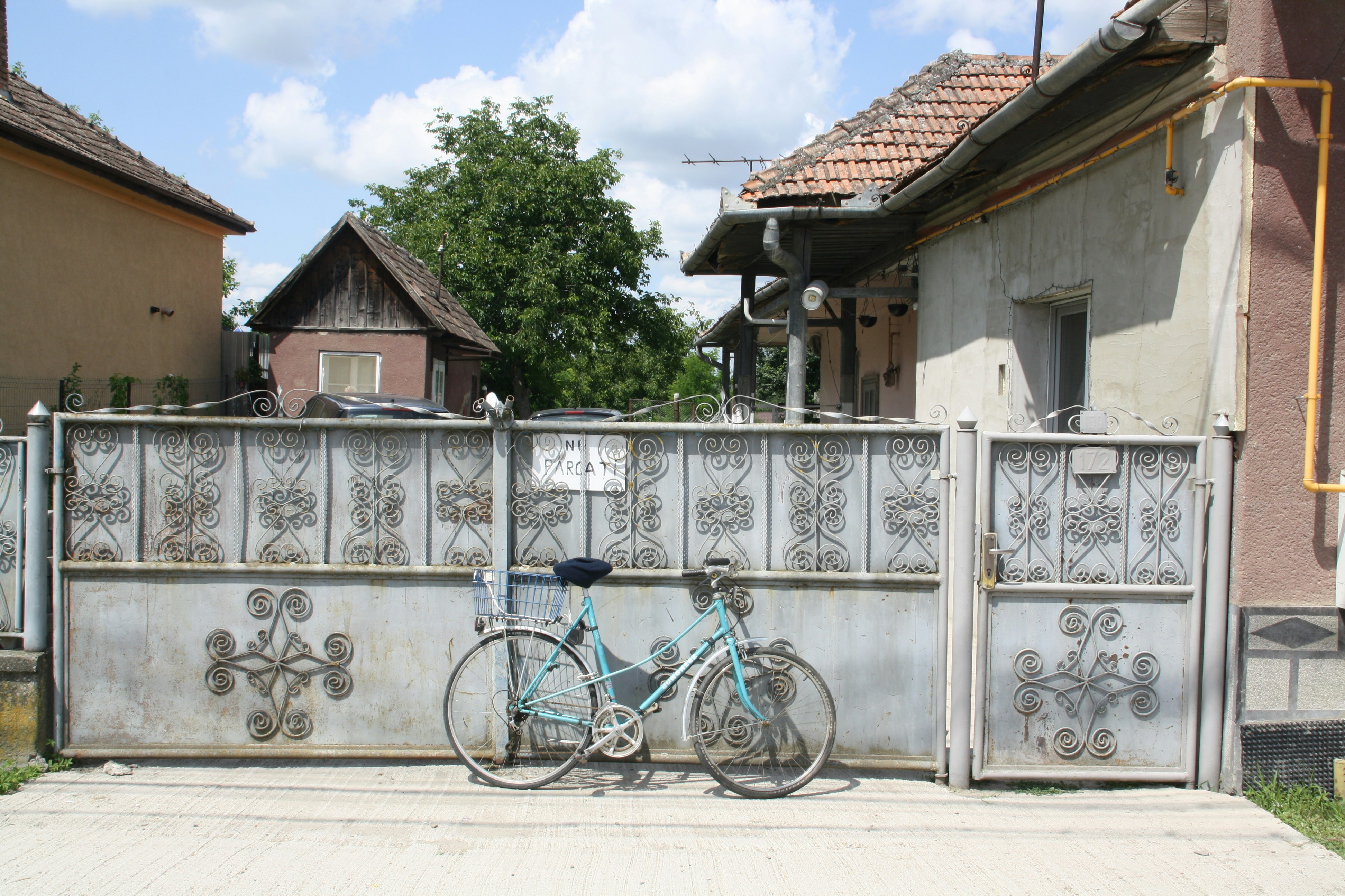 a blue bicycle parked next to a metal fence