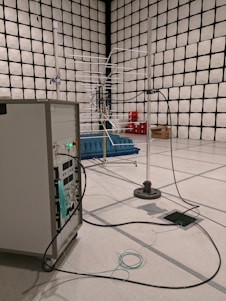 Technician performing RF shielding field testing with antennas and signal generators inside a secure facility.