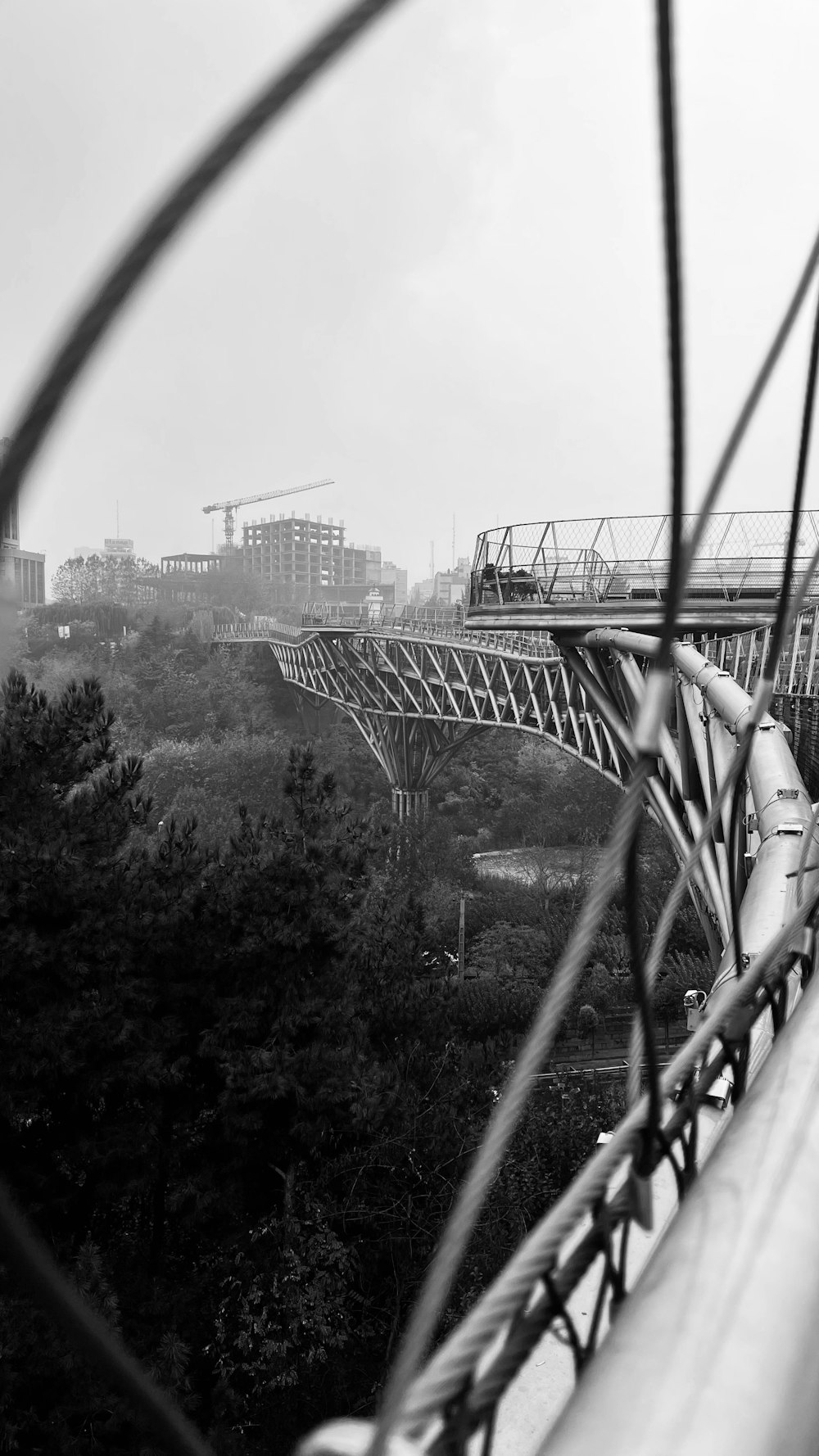 a view of a bridge from behind a wire fence