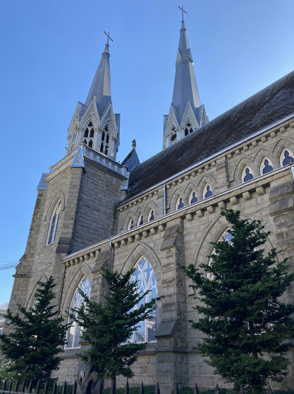 a church with two steeples and trees in front of it