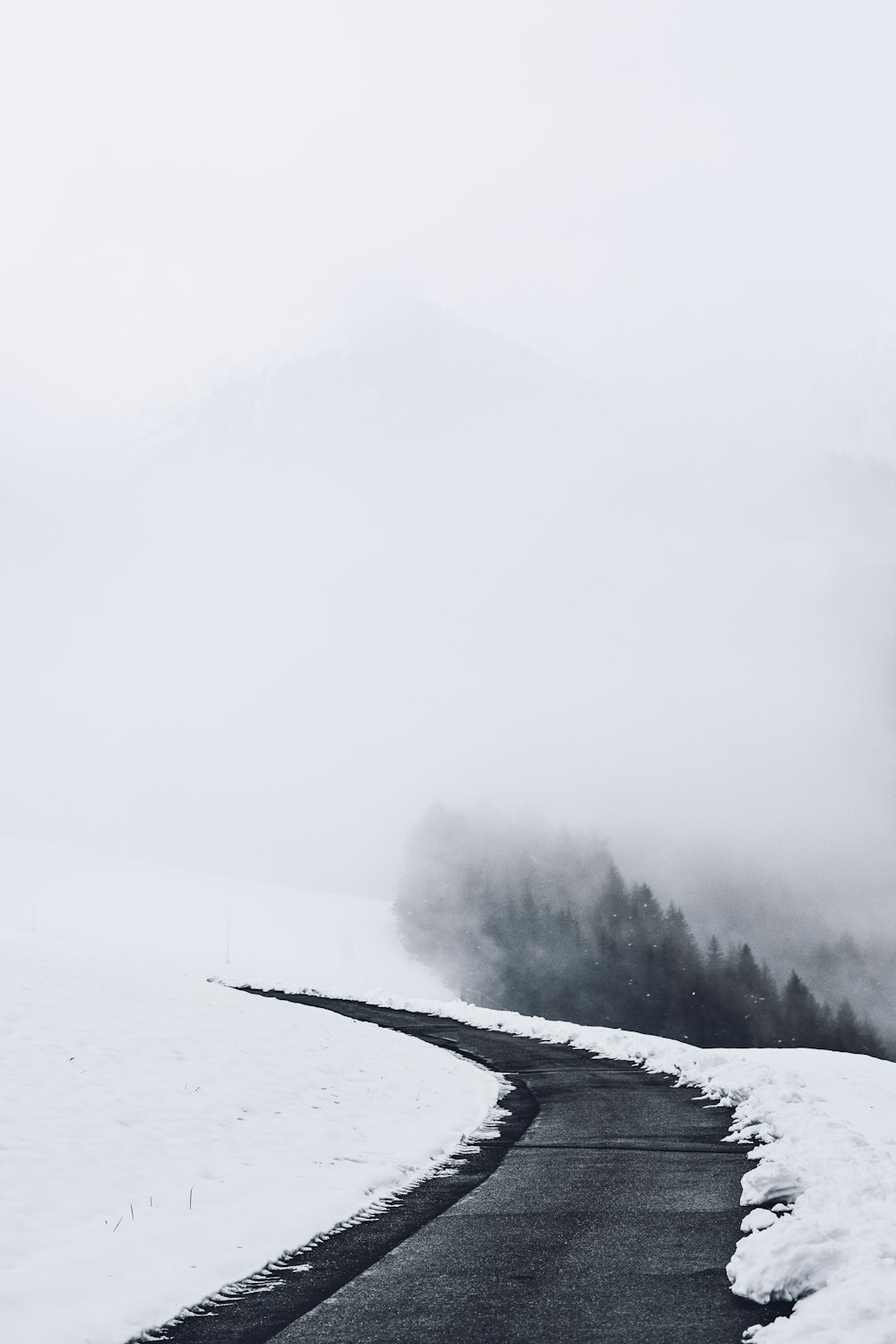 une photo en noir et blanc d’une route dans la neige