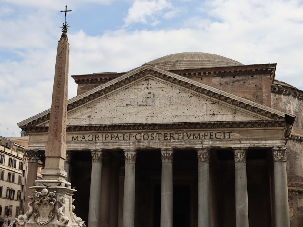 a large building with columns and a cross on top of it