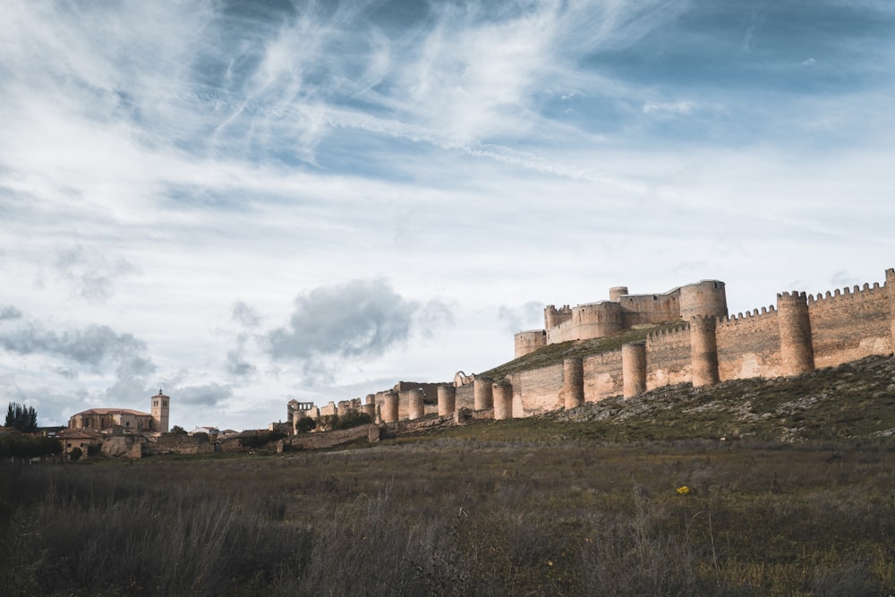 a large castle sitting on top of a lush green hillside