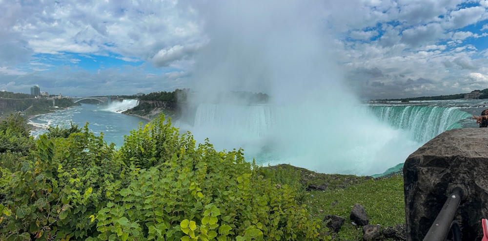 a person taking a picture of a waterfall