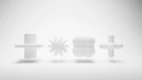 Abstract ceramic sculpture with geometric shapes in shades of gray on white surface.