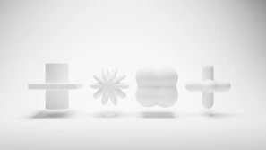 Abstract ceramic sculpture with geometric shapes in shades of gray on white surface.
