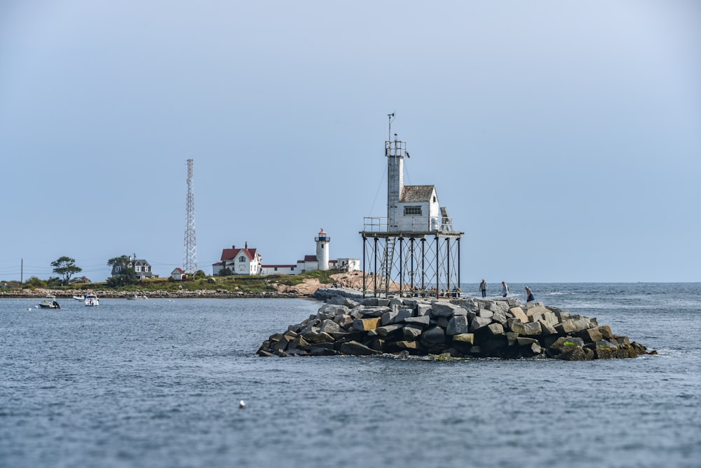 a light house on a rock outcropping in the middle of the ocean