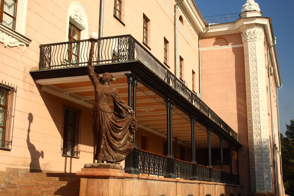 a statue stands in front of a building