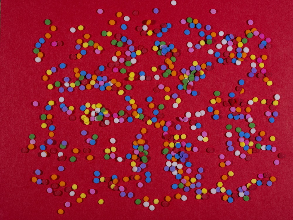 a red background with multicolored confetti sprinkles