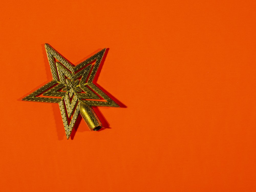 a star shaped brooch sitting on top of an orange surface