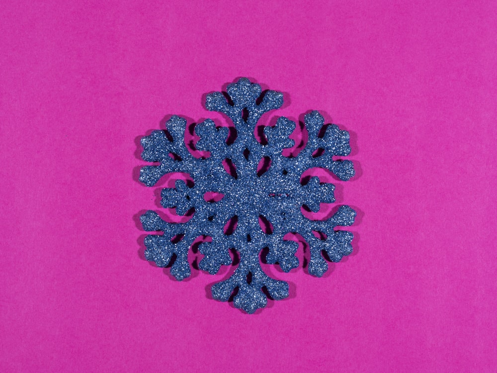 a blue snowflake on a pink background