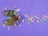Multiple small, colorful star-shaped confetti pieces are scattered across a purple background. Three small gift boxes, decorated with green, red, and gold reflective surfaces and tied with gold string, are placed among the stars.