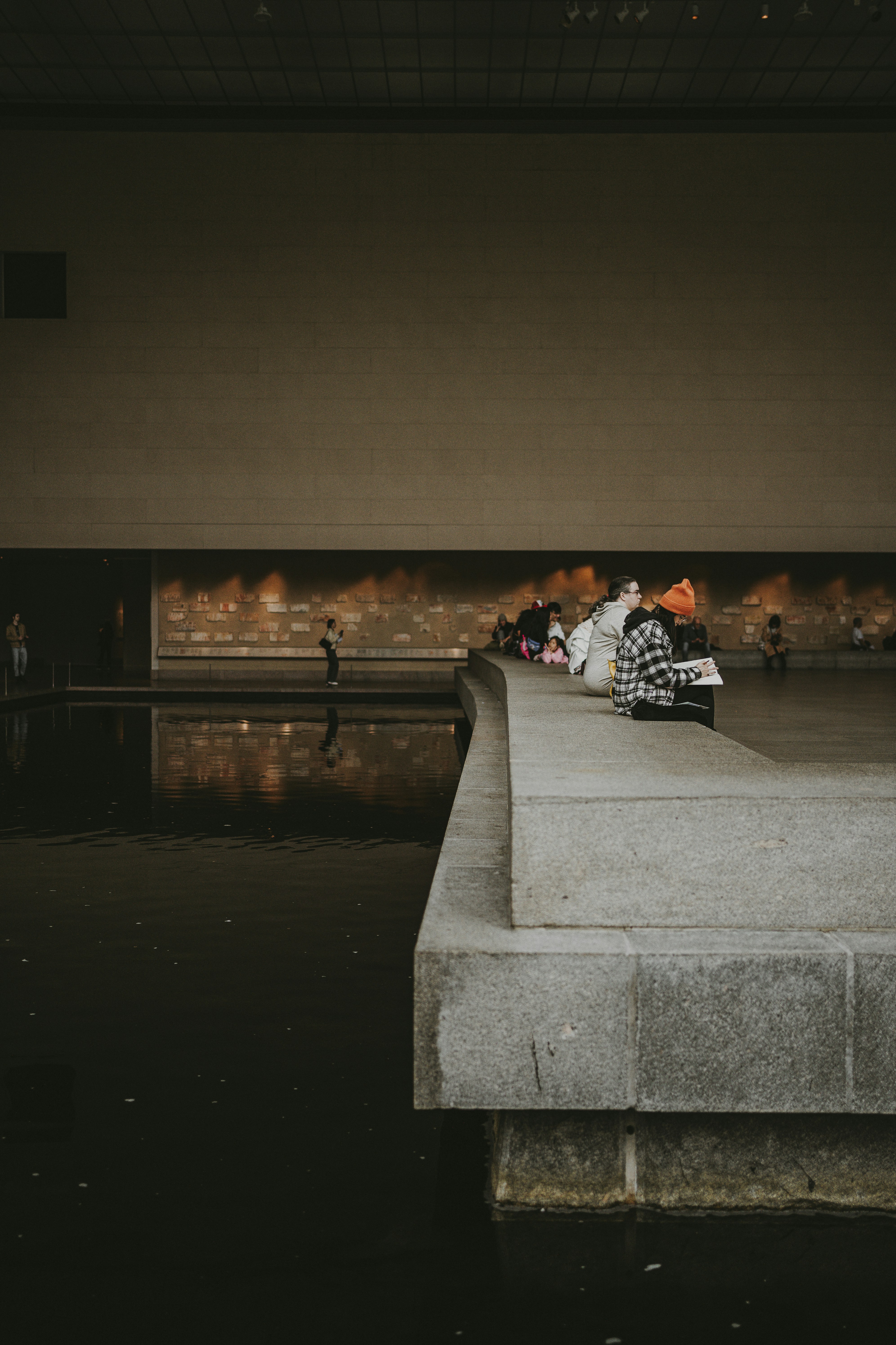 a group of people sitting on top of a cement bench