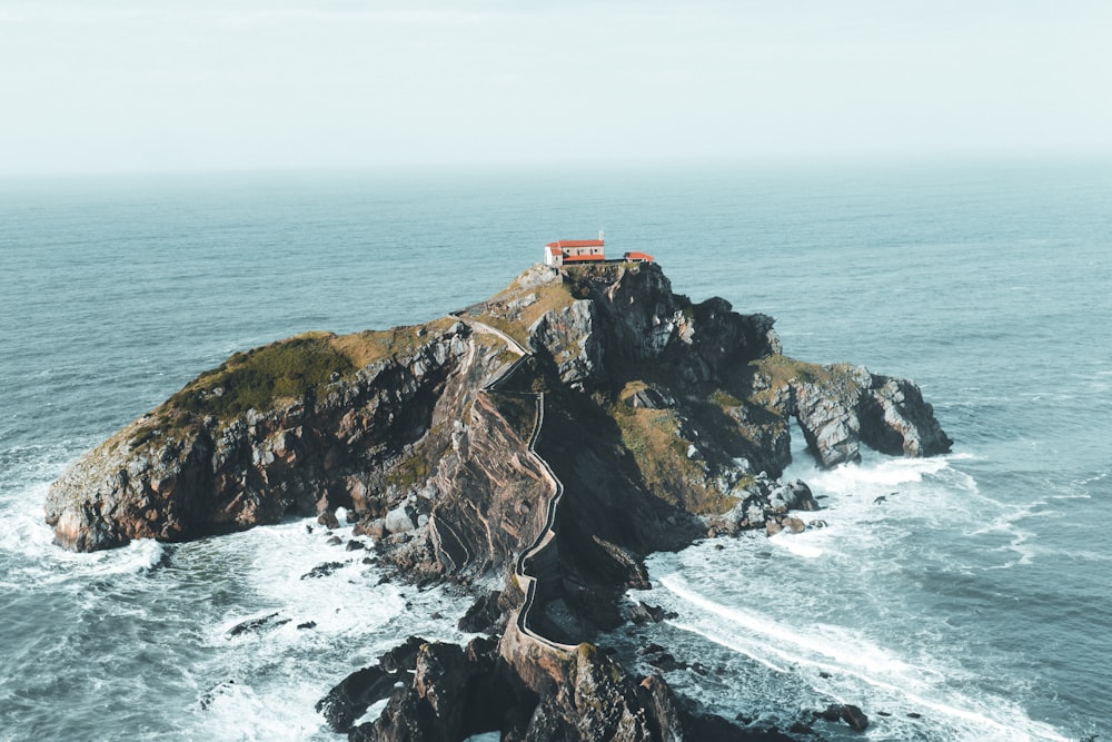 a small house on top of a small island in the middle of the ocean