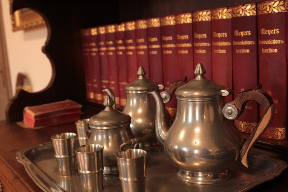 a silver tea set sitting on top of a metal tray