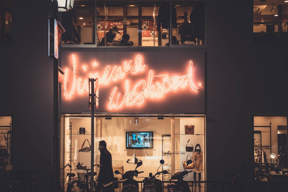 a store front with a neon sign above it