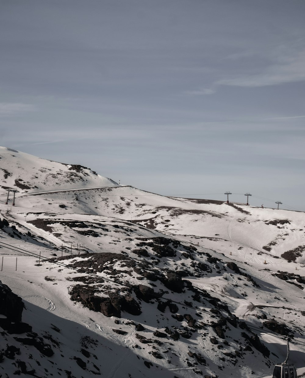 a snow covered mountain with a ski lift in the distance